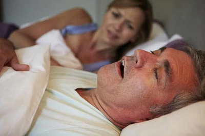 woman awake at night due to her husband's snoring from sleep apnea