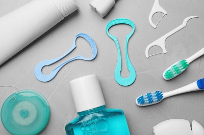 Dental care products including toothbrush, toothpaste, floss, mouthwash, and tongue scraper.