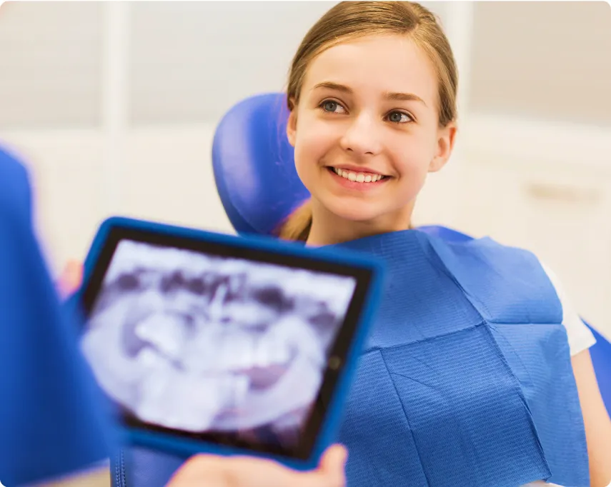 Young beautiful woman smiling while listening to the dentist explain dental x-ray on his tablet