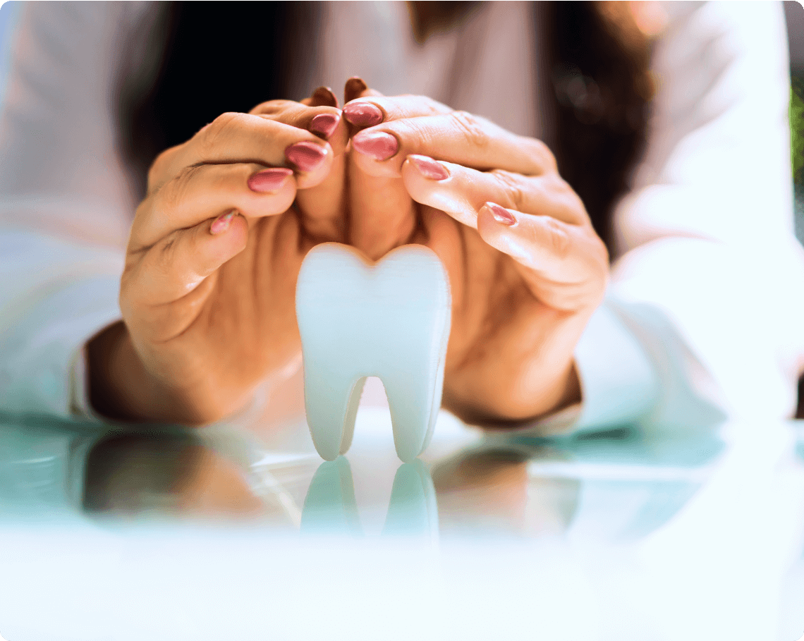 Close-up photo of a woman’s hands cradling a single human tooth in her palm.