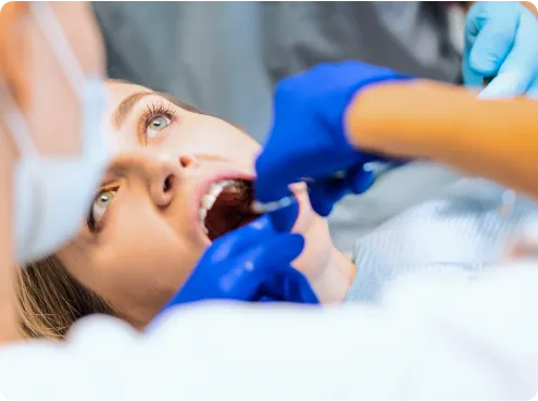 Dentist concentrates on a dental procedure for a relaxed female patient in a modern dental office.