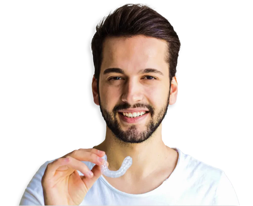Man beams with a confident smile, holding a pair of invisible aligners for teeth straightening.