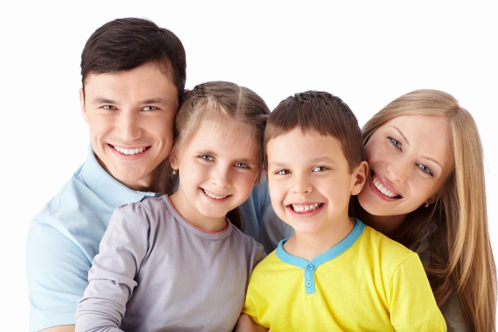 Happy family of four beams with bright smiles, creating lasting memories together.