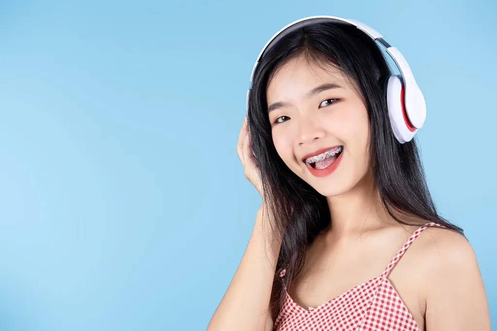 Young woman wearing braces smiles confidently while using a headset.