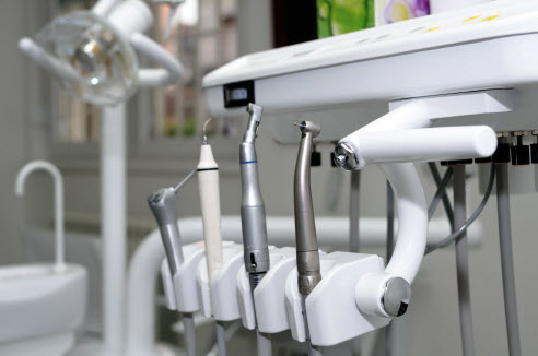 Close-up photo of dental instruments on a stainless steel tray.