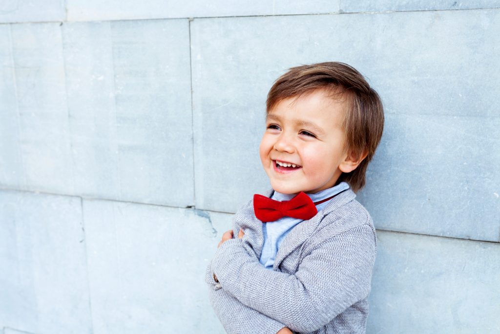 Adorable young boy in a bow tie, charming everyone with his bright smile
